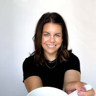 image of professional woman holding skin care bowl facing camera smiling. 