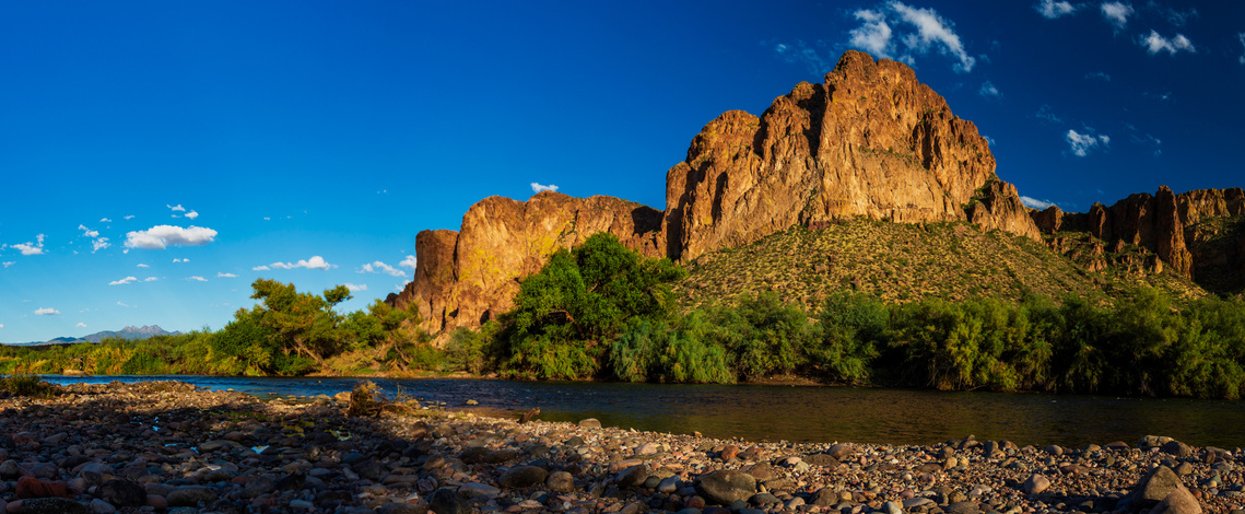 View along the Salt River in Arizona with scattered clouds and Four Peaks mountain in the distance.