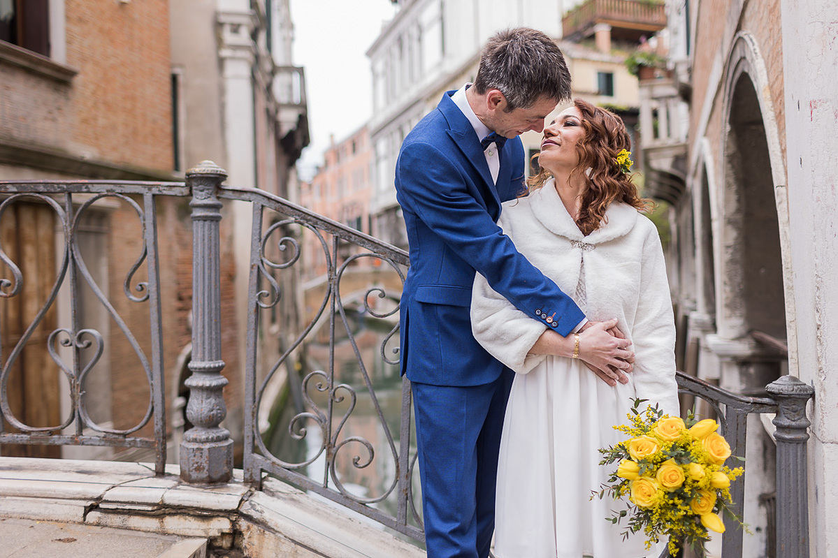kiss on a venetian bridge on the way to the city hall