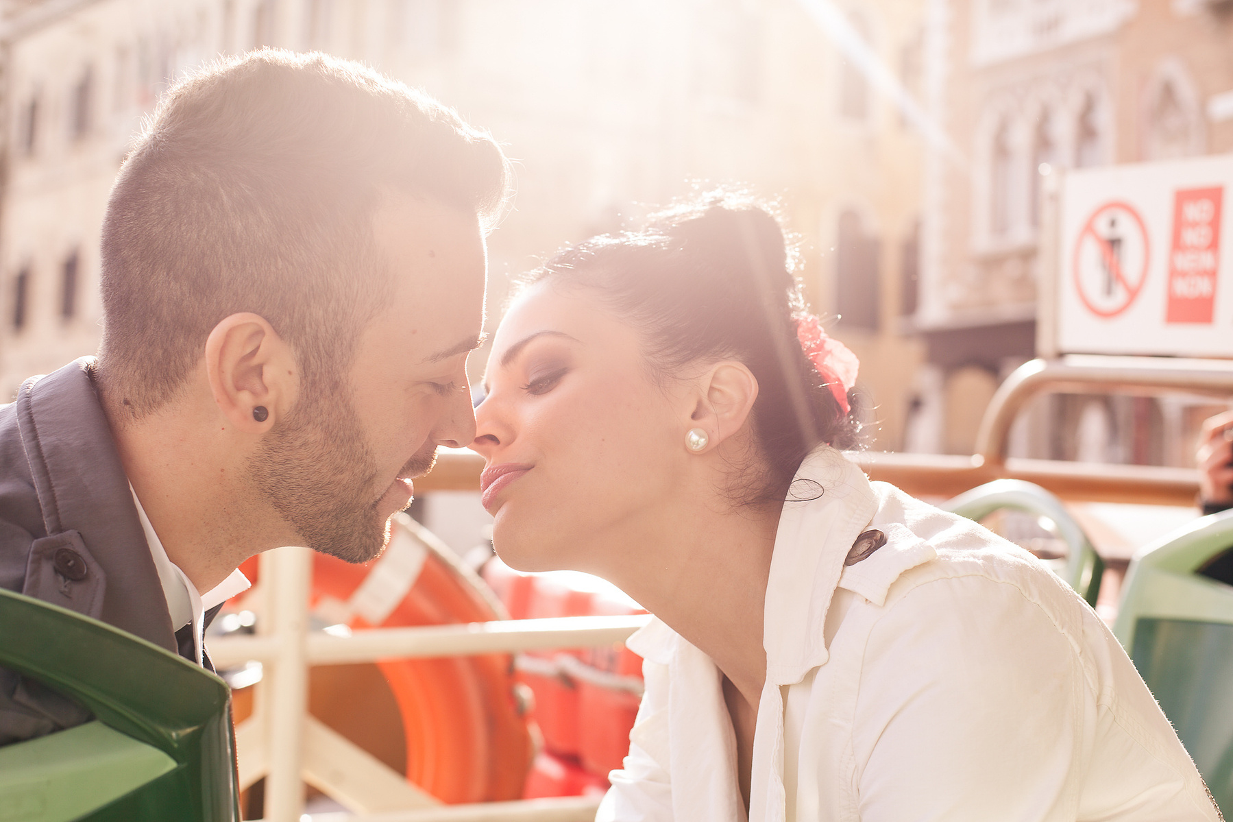 couple kissing wrapped in a glowing embrace from the sun on their way to the marriage ceremony in Venice.