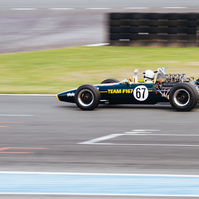 Jim Clark Tribute race car at Nogaro Circuit in France. Passing the finish line with raised finger