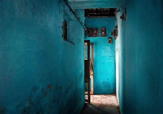 Blue walled walkway with wide open wooden grilled doors