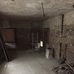 Wohnzimmer vor dem Umbau. Hinten rechts erkennt man den Notausgang, der bei Luftangriffen im 2. Weltkrieg verwendet wurde. 