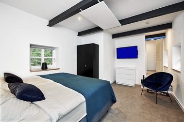 Schlafzimmer mit gemütlichem Boxspringbett von SwissSense 180x200 und SmartTV.
