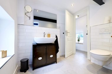 Badezimmer im industrial Design mit offener Dusche und Bodenbeschichtung in Betonoptik.