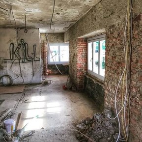 Wohnzimmer im Rohbau mit den neuen Holzfenstern. Lost Place.