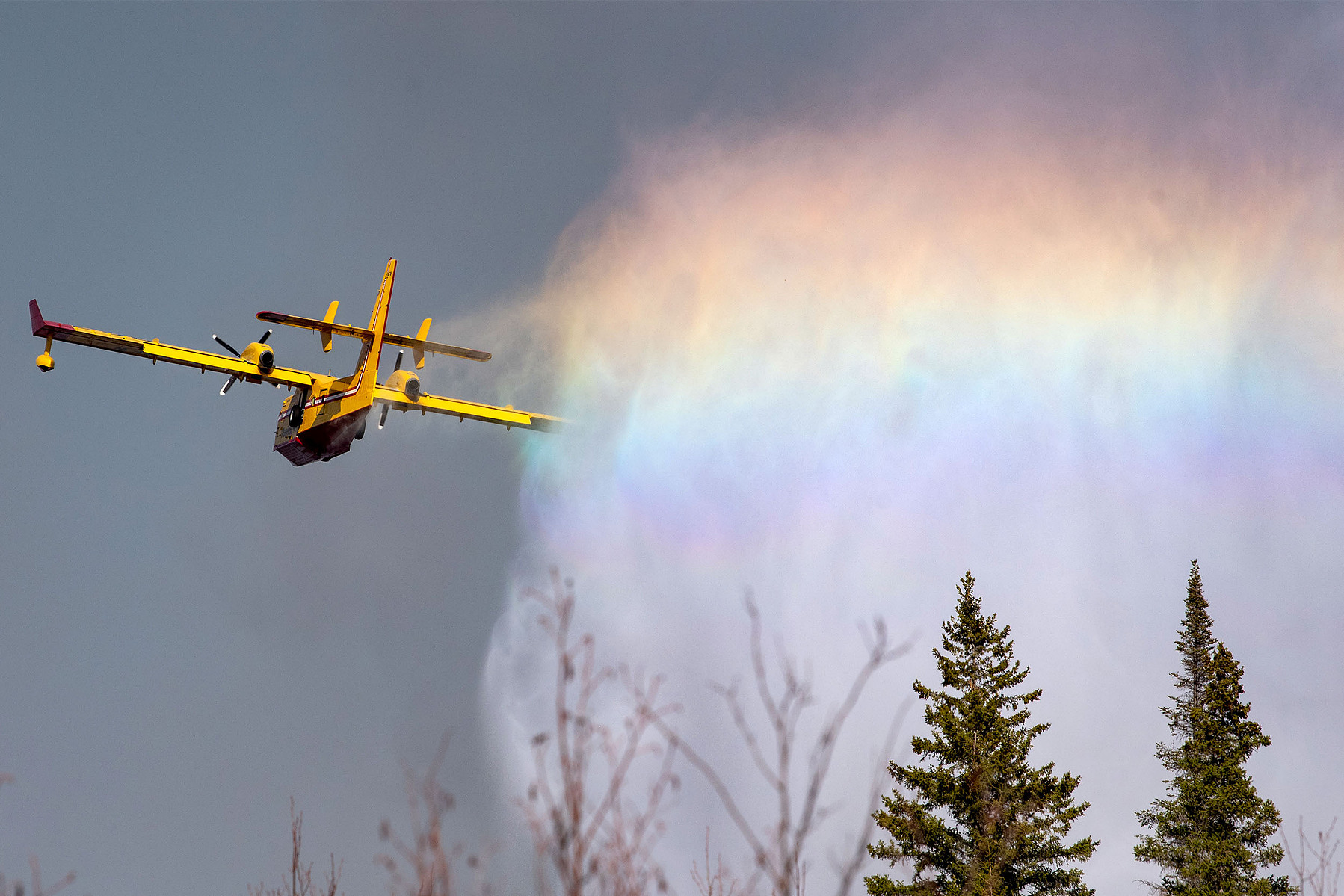 A plane drops water onto a forest fire in Manitoba.
