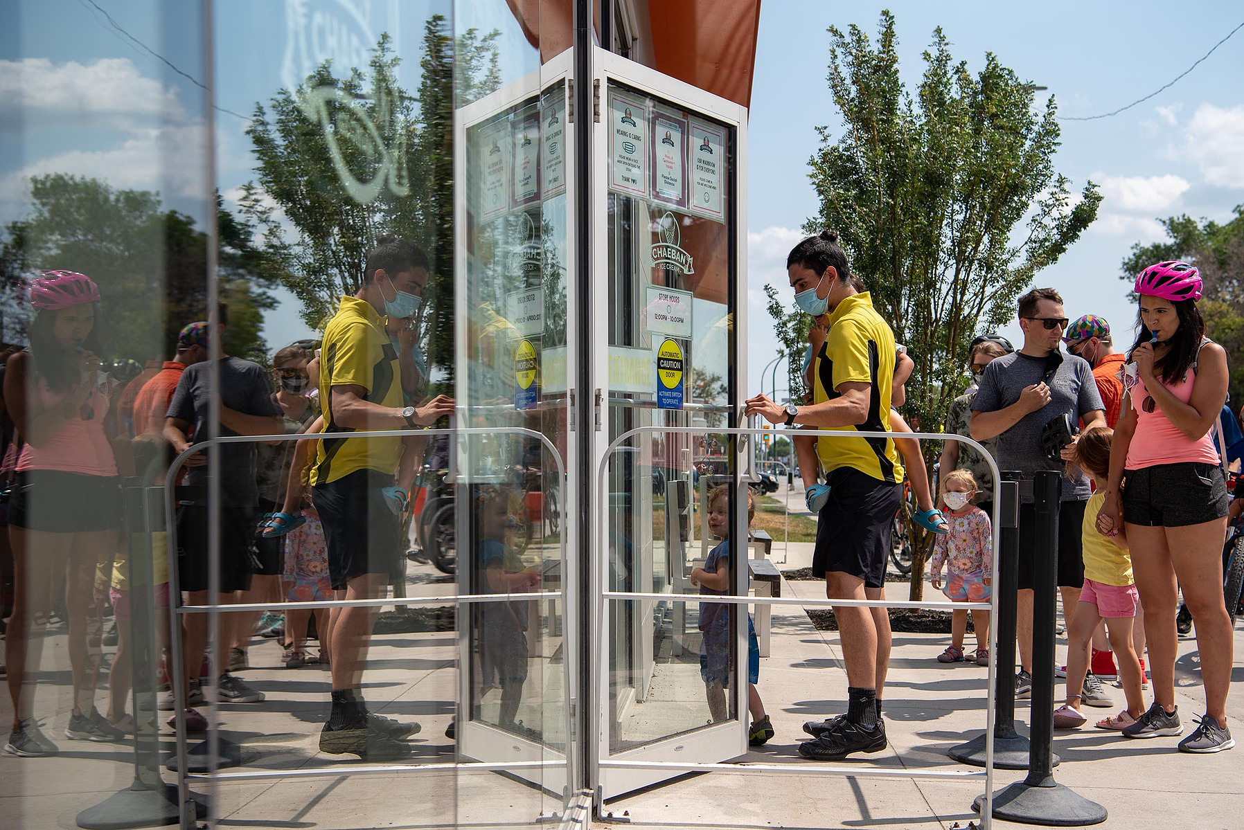 Cyclists taking part in the Tour de Glace, a 20-kilometre recreational event which makes stops at four local ice cream shops, wait in line outside of Chaeban Ice Cream in Winnipeg on July 24, 2021.  Photo by Alex Lupul