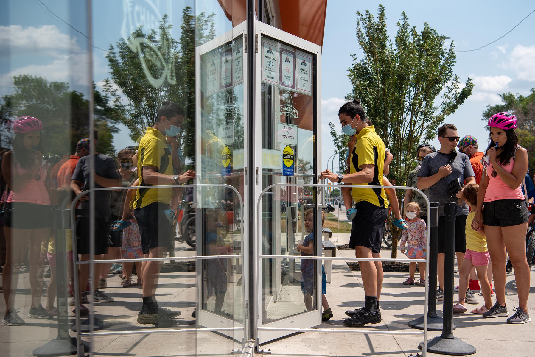 Cyclists taking part in the Tour de Glace, a 20-kilometre recreational event which makes stops at four local ice cream shops, wait in line outside of Chaeban Ice Cream in Winnipeg on July 24, 2021.  Photo by Alex Lupul