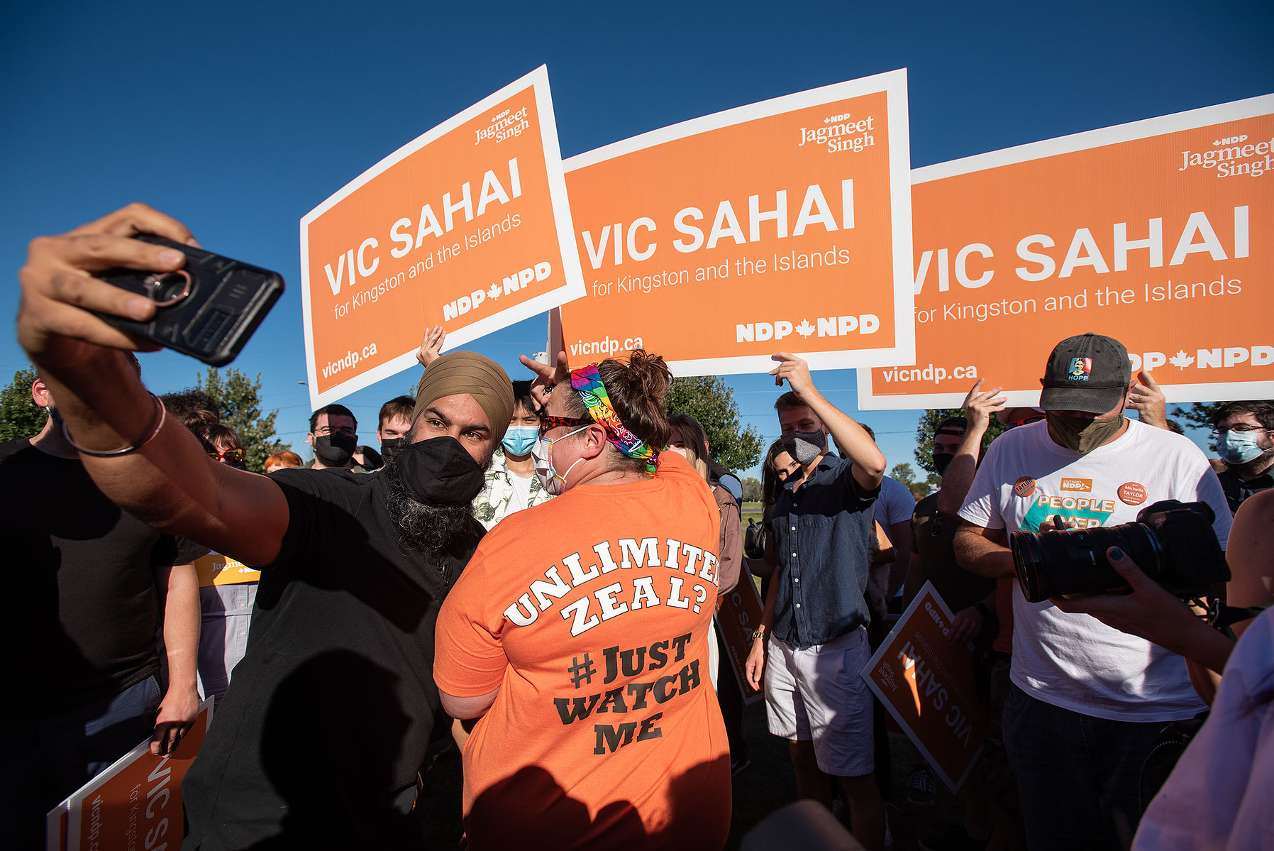 NDP leader Jagmeet Singh takes a photo with a supporter wearing a shirt referencing “unlimited zeal” at Lake Ontario Park in Kingston, Ont. on Sept. 16.