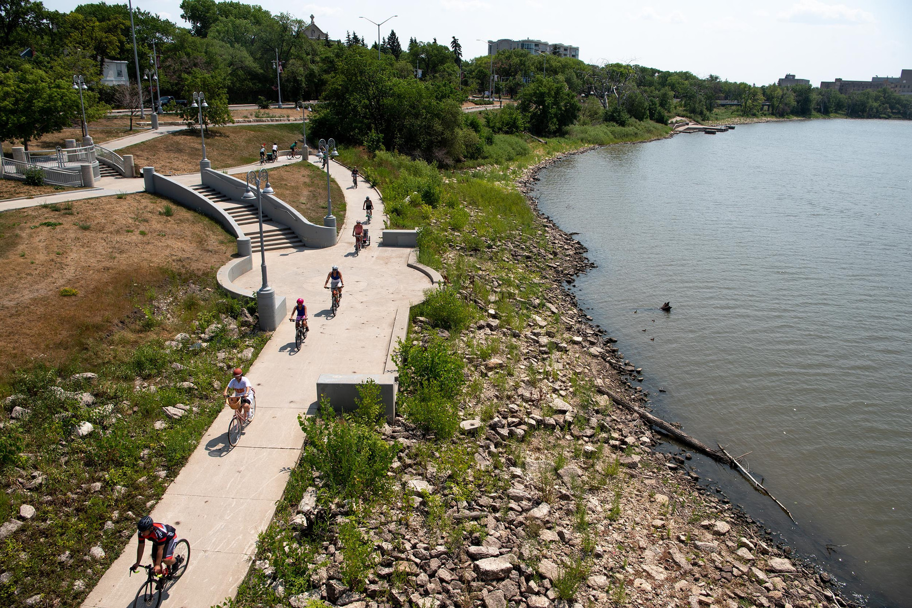 Cyclists taking part in the Tour de Glace, a 20-kilometre recreational event that makes stops at four local ice cream shops, ride below Esplanade Riel in Winnipeg on July 24, 2021. Photo by Alex Lupul