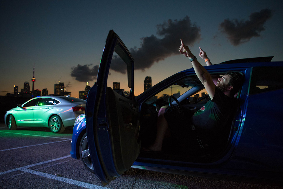 A man sings along from his car during an outdoor drive-in concert in Toronto.