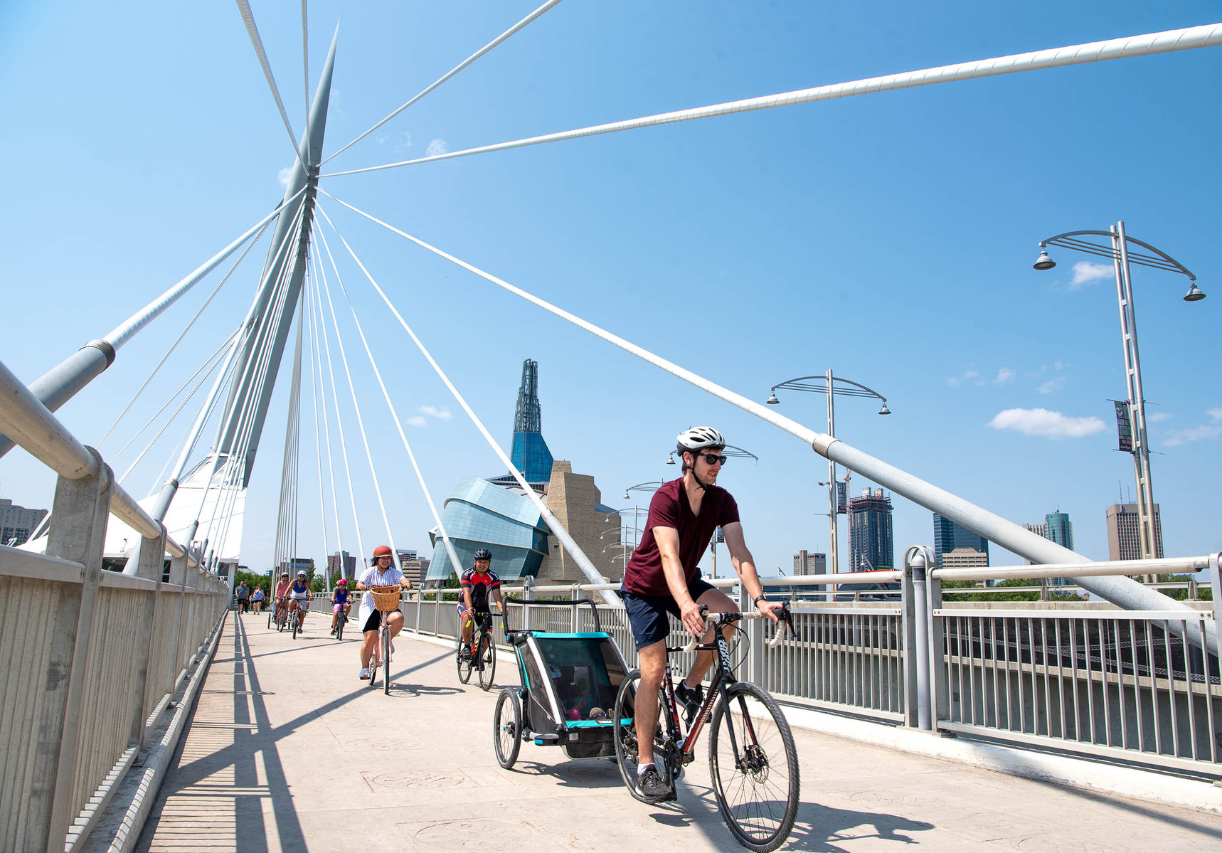 Cyclists taking part in the Tour de Glace, a 20-kilometre recreational event which makes four stops at local ice cream shops, ride on Esplanade Riel in Winnipeg on July 24, 2021. Photo by Alex Lupul