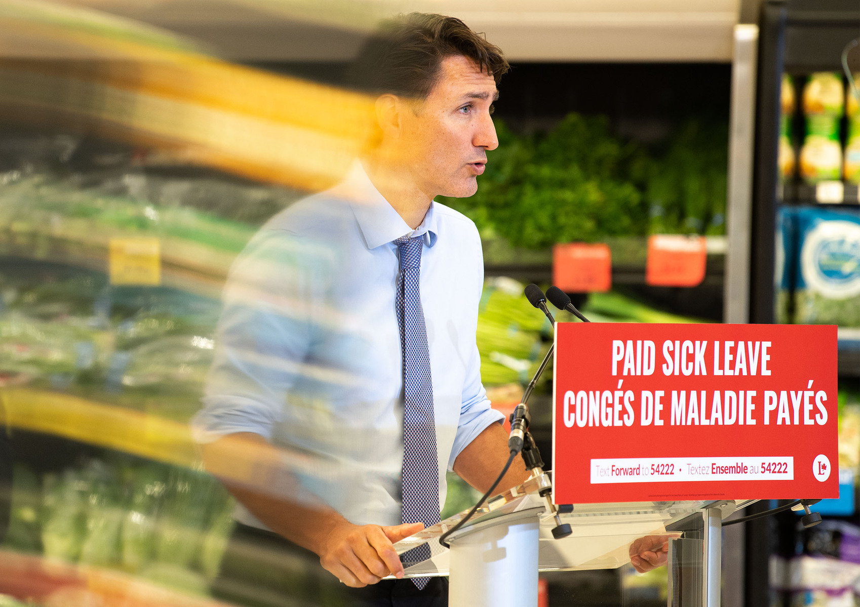 Food is seen reflected on a plexiglass shield while Liberal Leader Justin Trudeau speaks during a campaign stop at the Cavalier Drive FoodFare location in Winnipeg on Aug. 20, 2021. Photo by Alex Lupul
