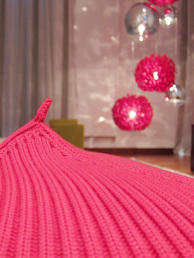 Pouf von Casalis, Bonett, im Vordergrund. Sitzpouf.
Klassische Kugel Tom Dixon Mirror Ball Pendelleuchten in Silber kombiniert mit roter Seidenleuchte von Angoworld. Beleuchtung mit schönem Lichtspiel.