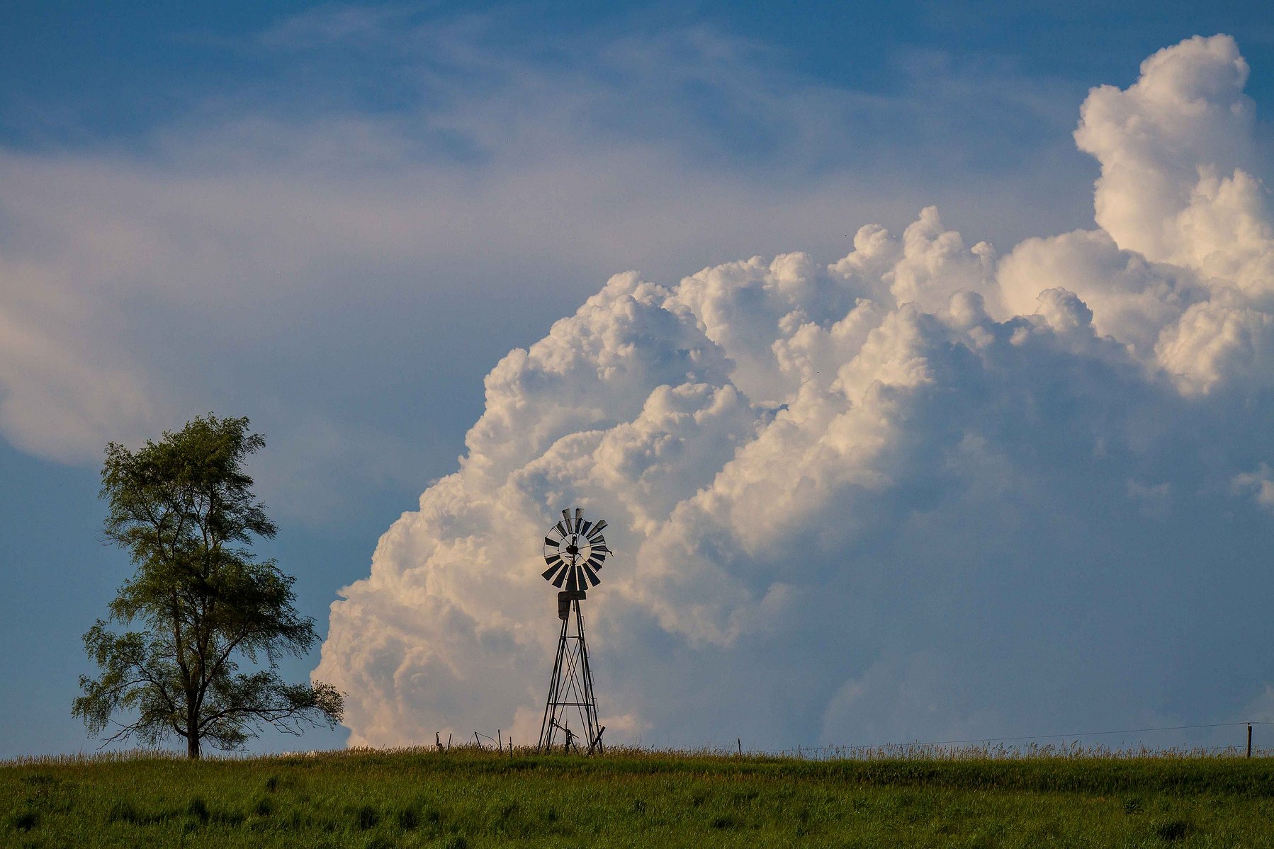 impending storm clouds rise behind a broken down windmill in Malcom, Nebraska.