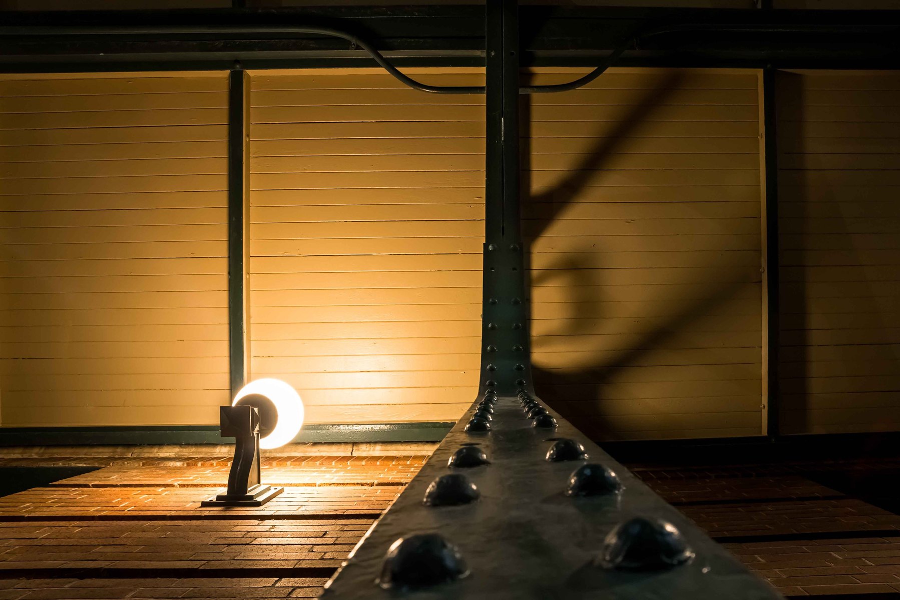 Looking up at a pillar next to a lamp at night.