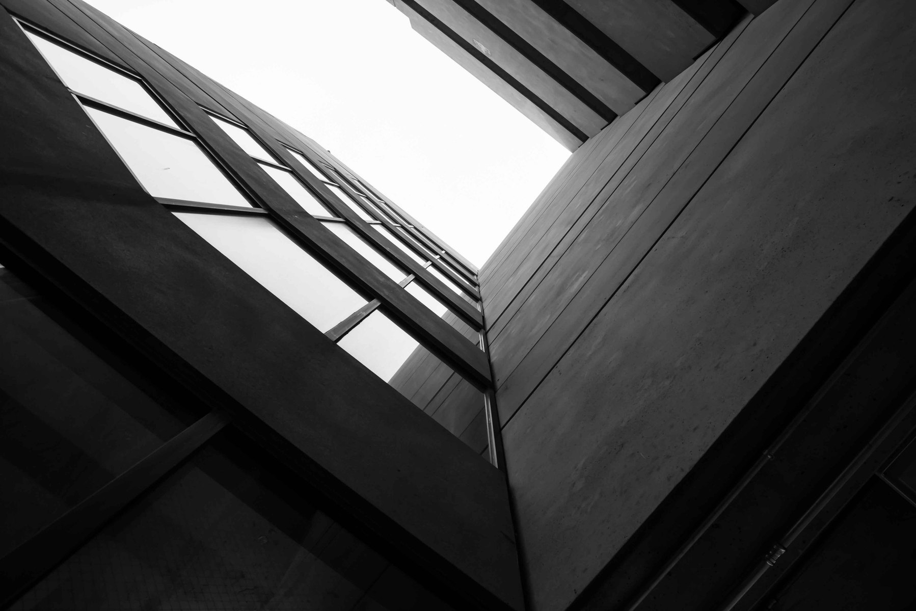 Looking up at a parking garage with windows going toward the sky.