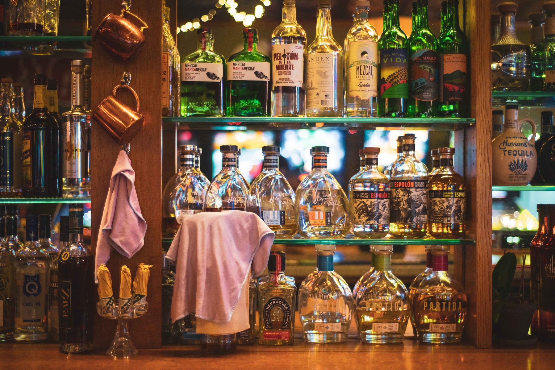 An image of the back of a bar stocked with tasty drinks.