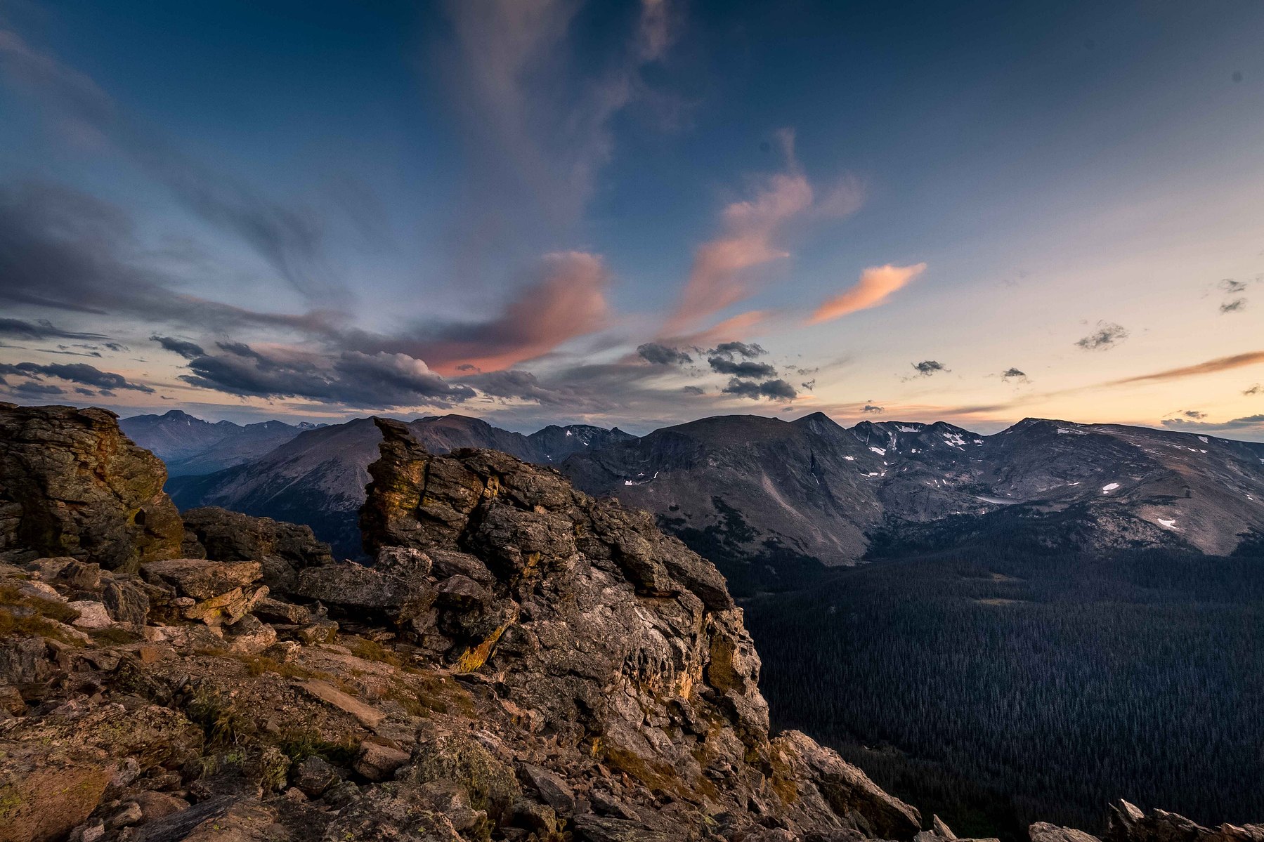 Jagged rocks jut out of the ground against wind swept clouds in Colorado.