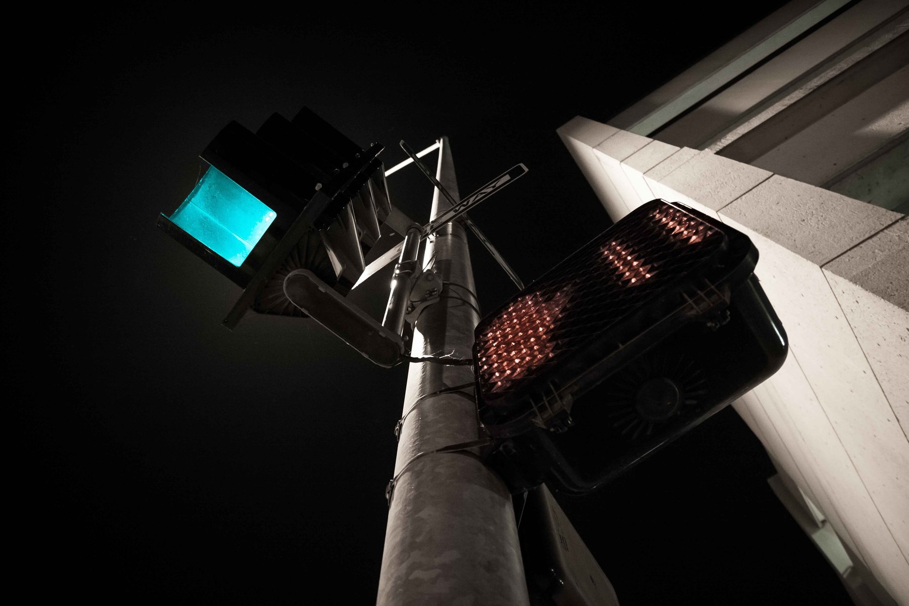 Looking up at a street lamp in the city at night.