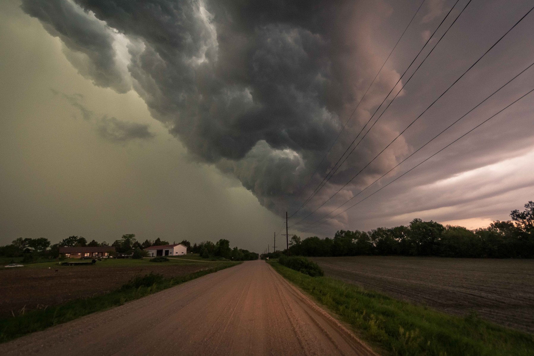 Violent dark storm clouds swirl over a road in rural Nebraska.
