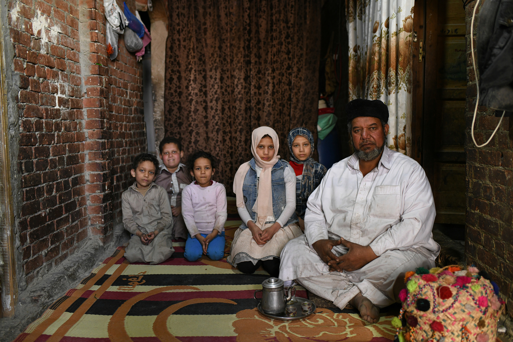 A portrait of Omar Khattab with five of his ten children, at his home in the Siwa Oasis.