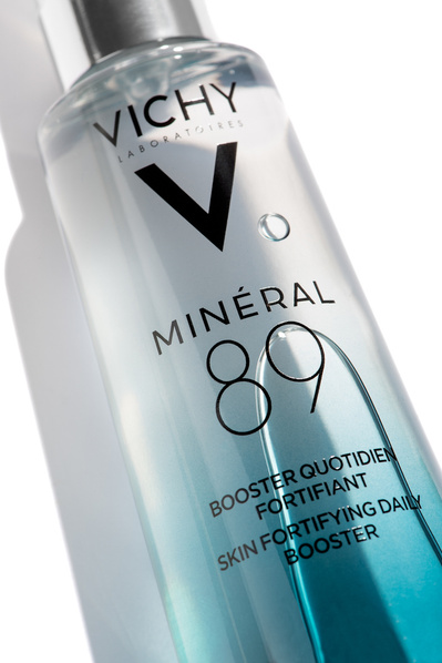 Produit skincare hydratant liquide dans un flacon bleu, sur fond blanc. 