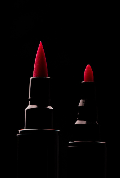 Pointes de feutres rouges sur fond noir.