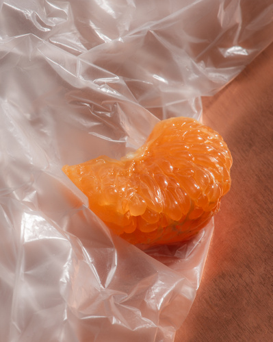 Pulpe de clémentine sur sac de plastique déposé sur fond de cuivre.
