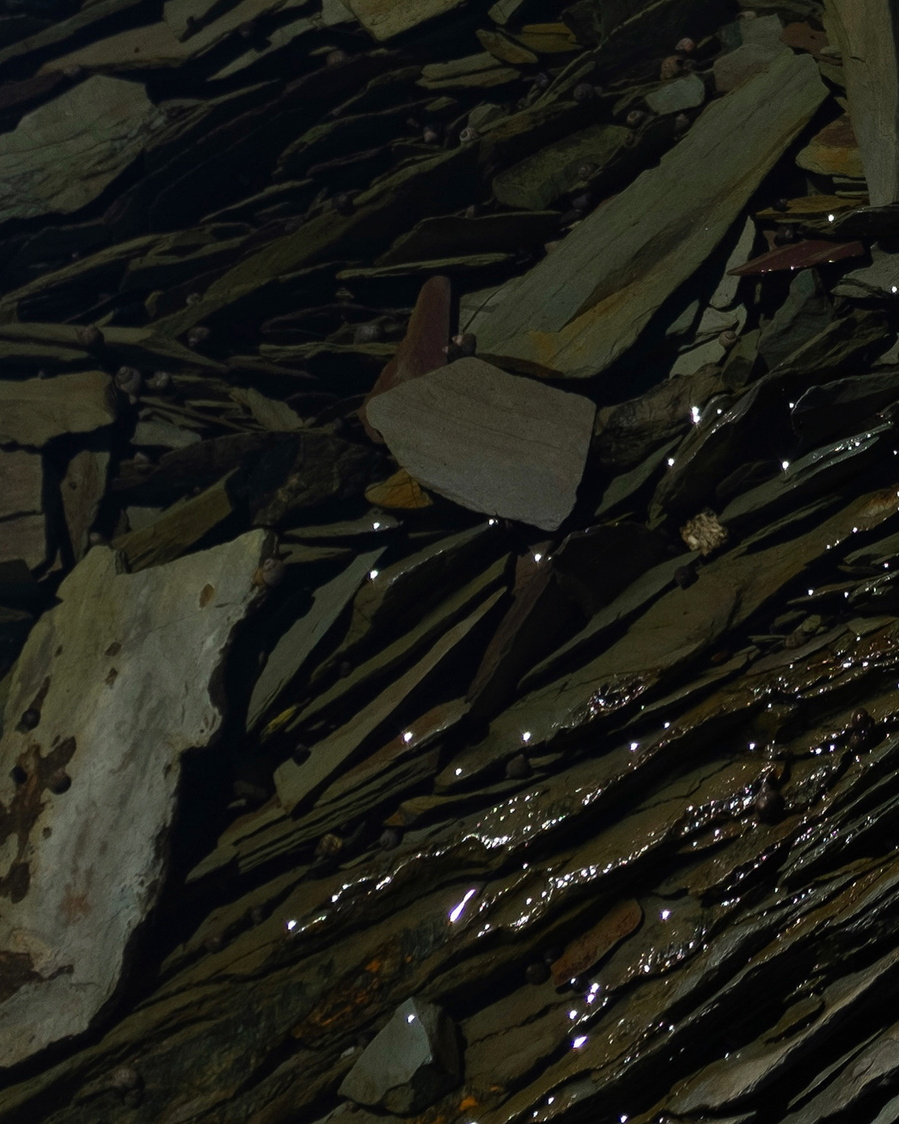 Roches brisées sous l'eau avec le soleil qui se reflète en points lumineux.