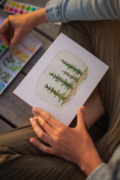 Femme faisant de l'aquarelle sur un quai en été.