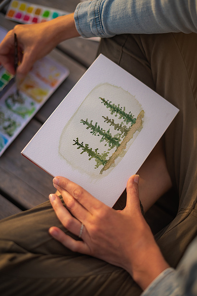 Femme faisant de l'aquarelle sur un quai en été.