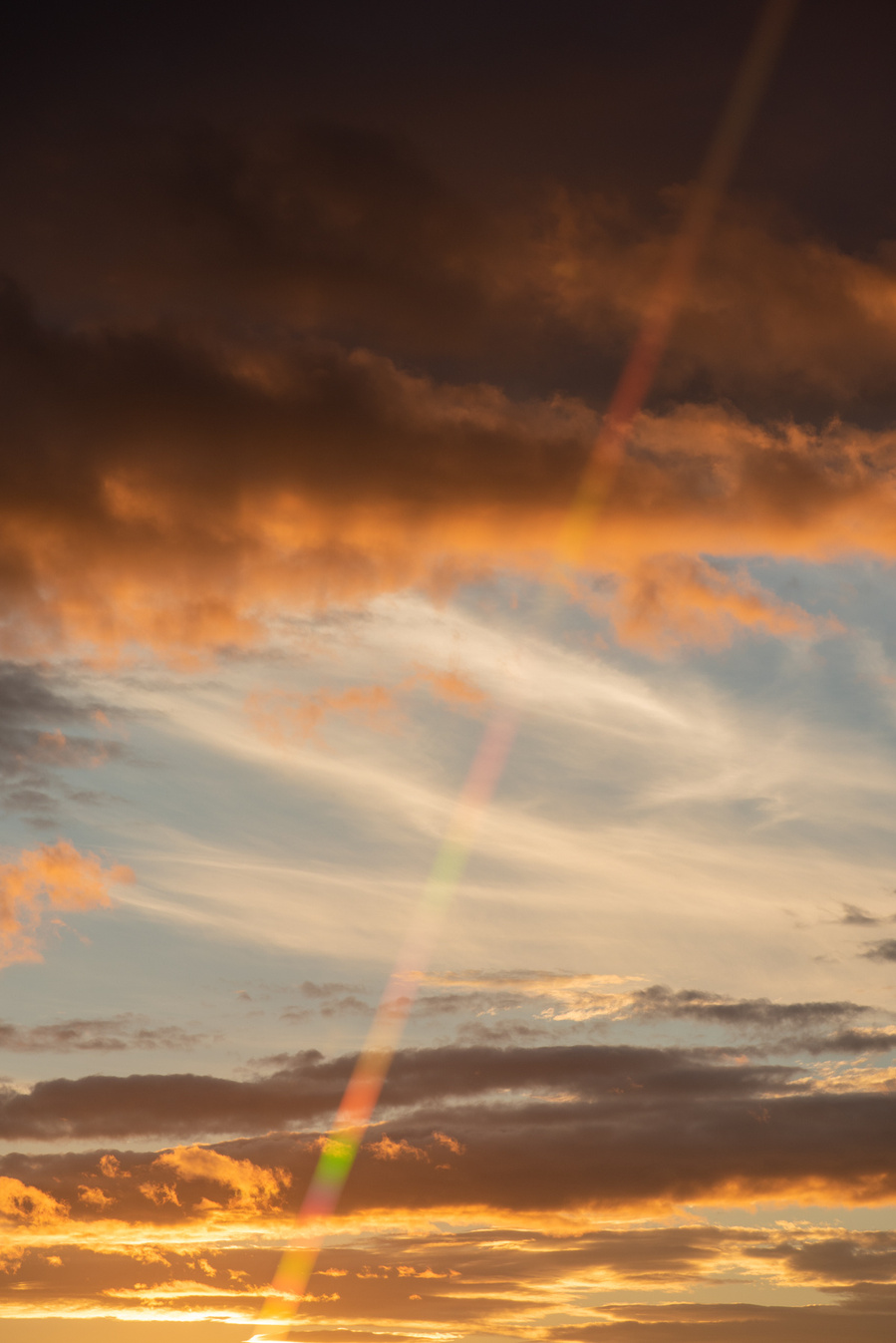Rayon multicolore devant un ciel de coucher de soleil. 