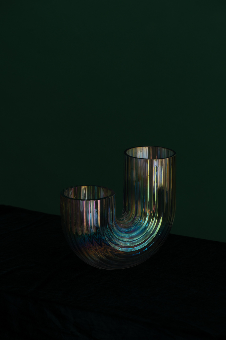 Vase en arc-en-ciel iridescent sur fond vert.