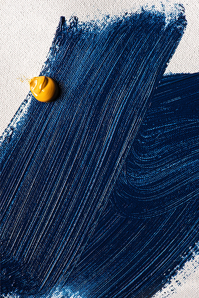 Traits de peinture bleue et tache jaune sur canevas.