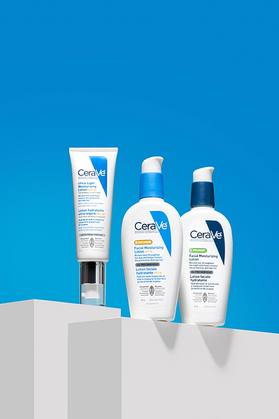 Trio de produits de beauté sur des blocs gris, sur fond bleu.