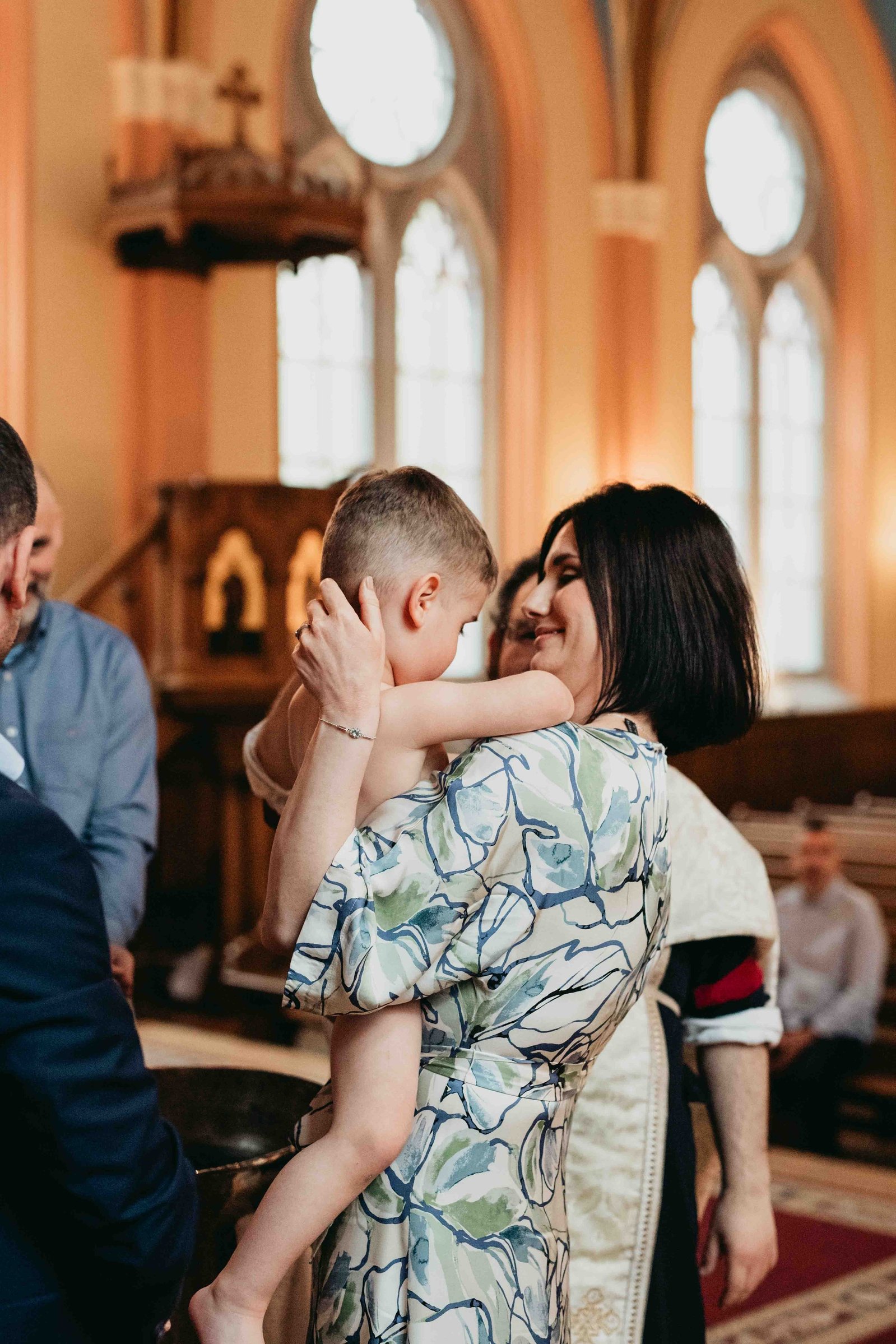 Mamma och son på dop i grekiska kyrkan i Stockholm.