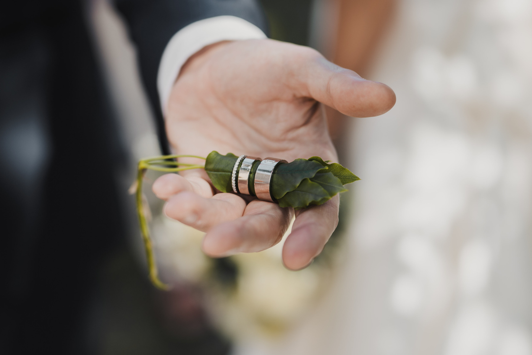 Brudgummen håller vigselringar i sin hand utanför Gustaf Vasa kyrka i Stockholm.