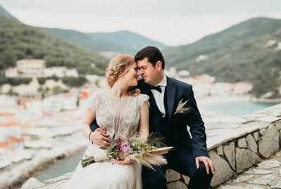 Lycka på elopement utomlands. Brud och brudgum i en intim stund med bakgrund över medelhavet, i Parga Grekland.