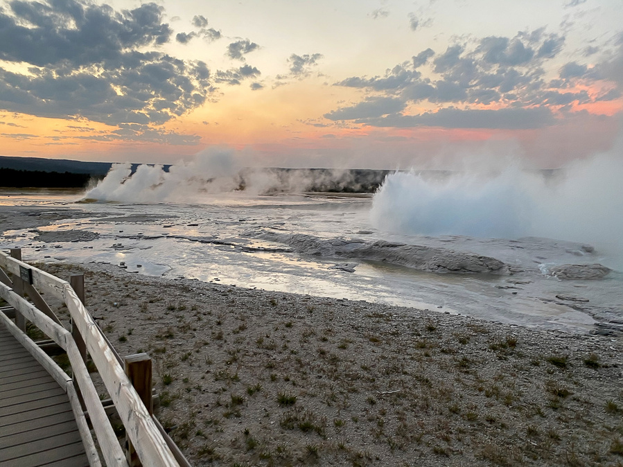 Near Fountain Paint Pot in Yellowstone National Park, steam rises above a hot spring pool during a Wyoming sunset. September 2020