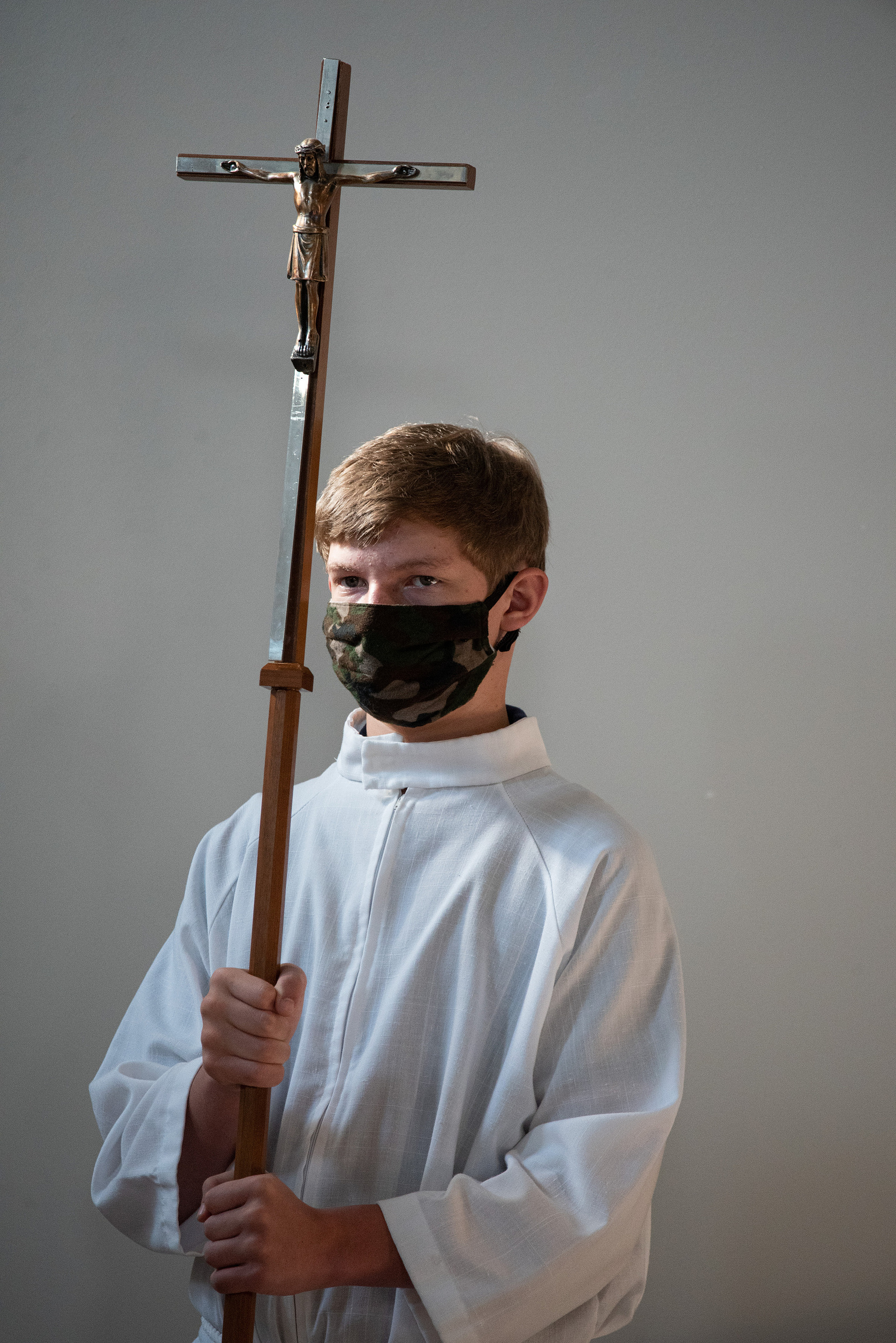 Simon Schmidt bears the cross during the service of dedication at St. Luke’s Lutheran Church on Sunday.