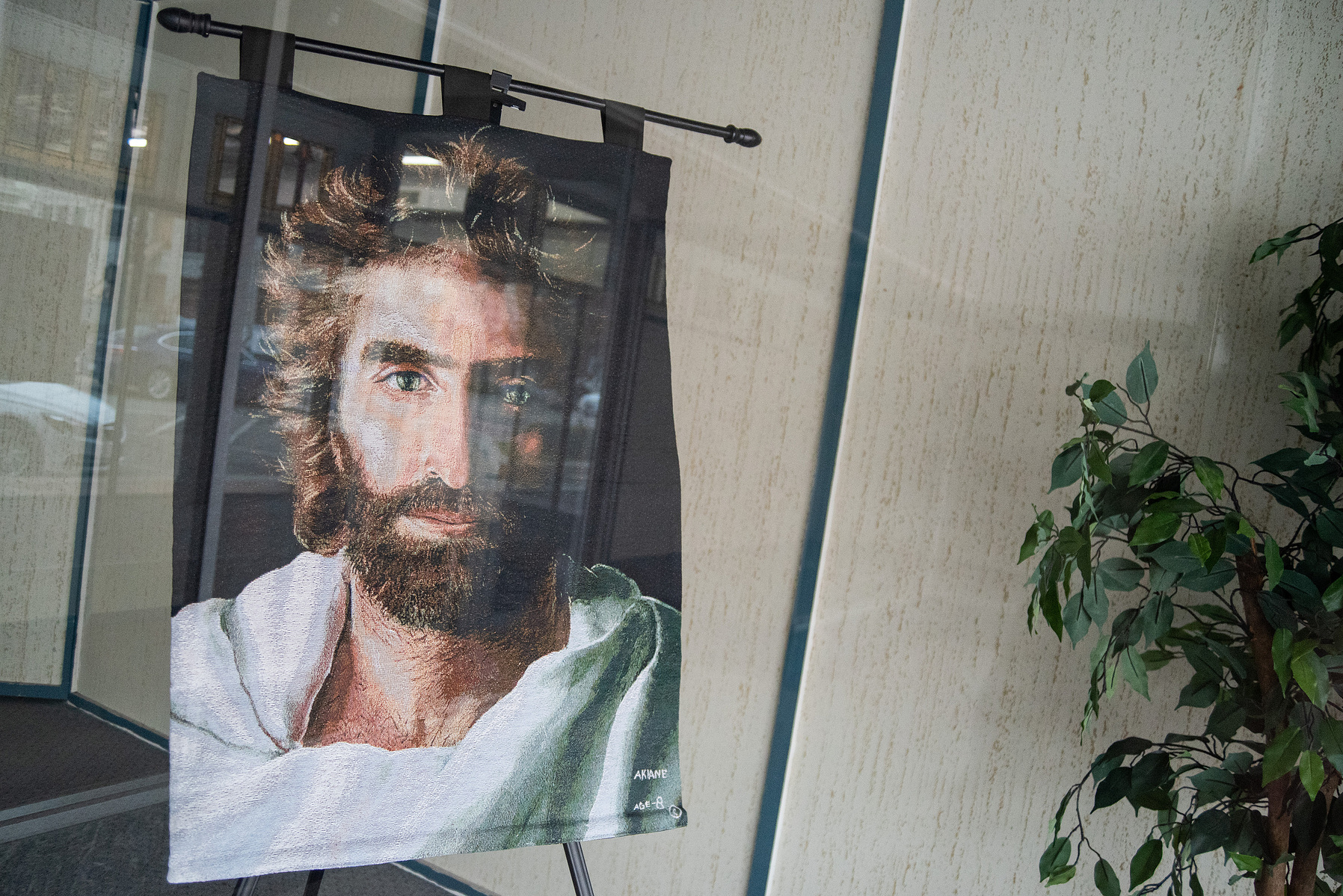 A stitched Jesus Christ sits in the front window of the Manhattan Christian Fellowship Church on Sunday.