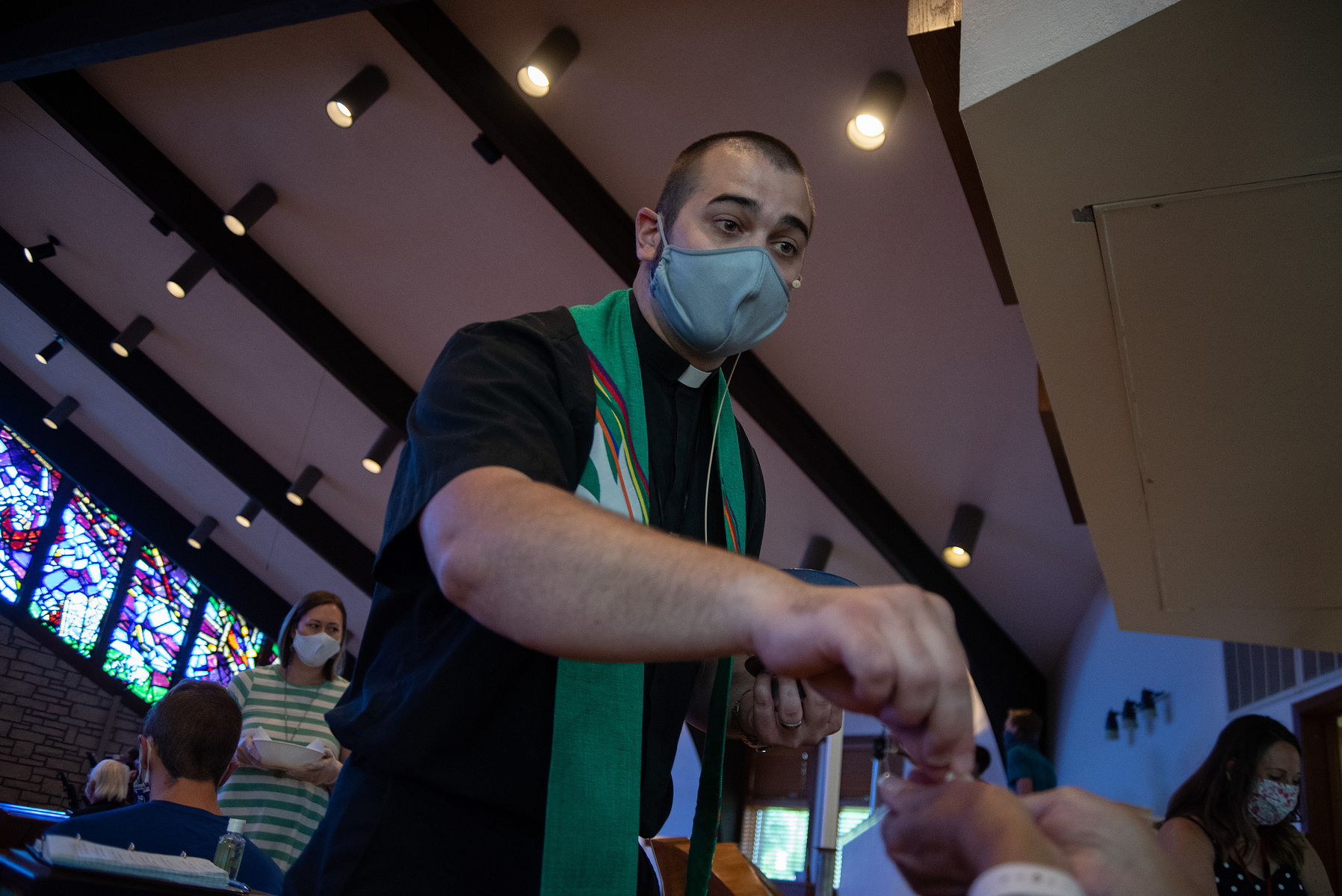 Pastor Austin English hands out communion to Kathy Stitt during Peace Lutheran Church’s Sunday service.