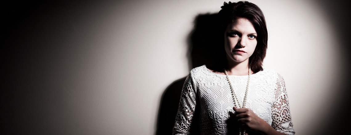 Portrait of a woman standing against a wall.  photography