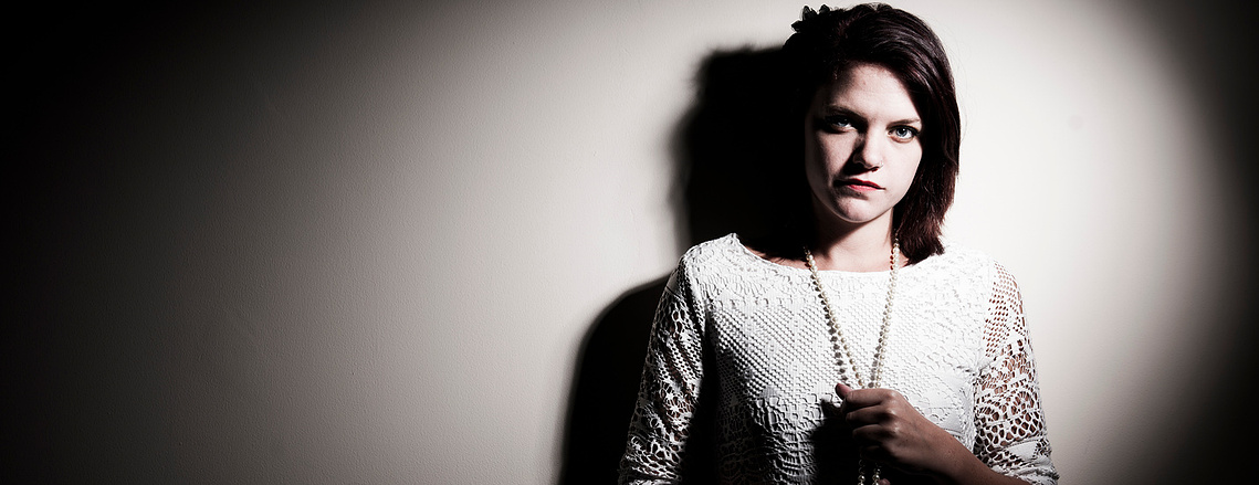 Portrait of a woman standing against a wall.  photography