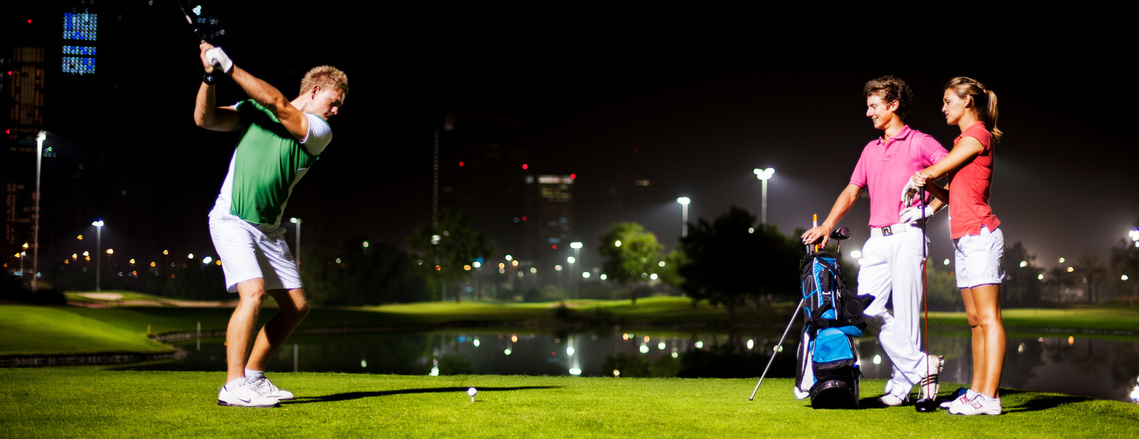 Golfers playing at night for a commercial photoshoot at a golf club