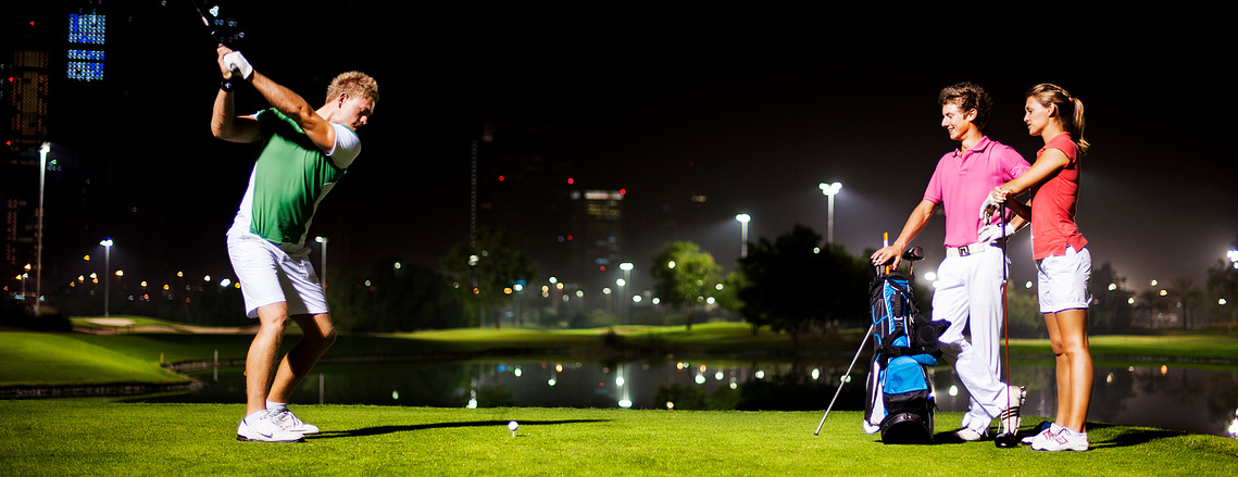 Golfers playing at night for a commercial photoshoot at a golf club