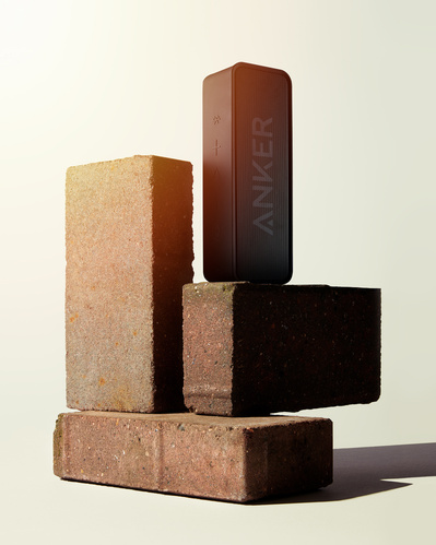 Made with Photography. A Bose speaker standing on three balancing bricks. 