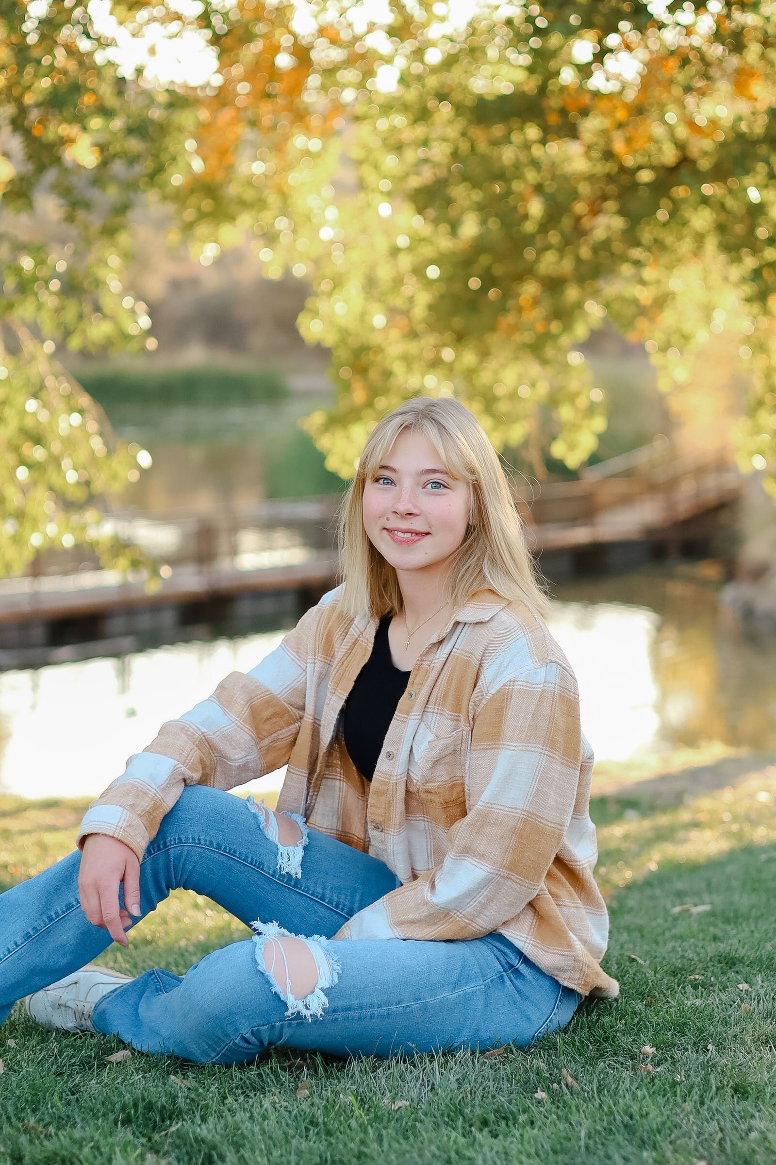 A homeschool portrait of a young lady at Fain Park in Prescott Valley highlights the individual child with a fall colors and a sunlit lake in the background.